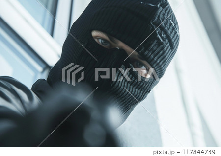 Close-up of a masked man pointing a weapon Close-up of a masked man pointing a weapon 117844739