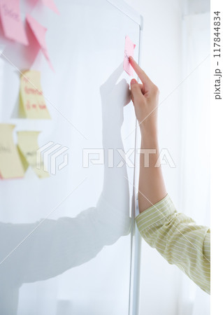 オフィスで課題を見える化する若い女性 117844834