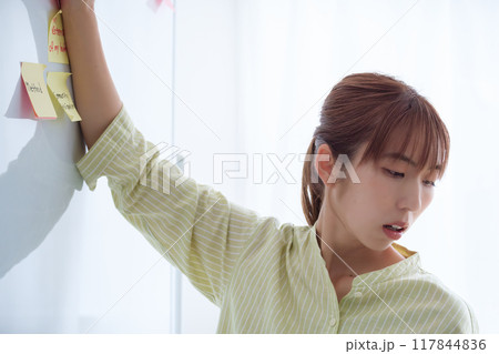 オフィスで課題を見える化する若い女性 117844836