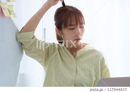 オフィスで課題を見える化する若い女性 117844837