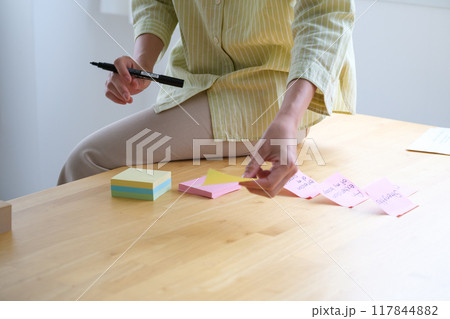 オフィスで課題を見える化する若い女性 117844882