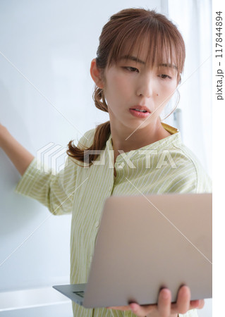 オフィスで課題を見える化する若い女性 117844894