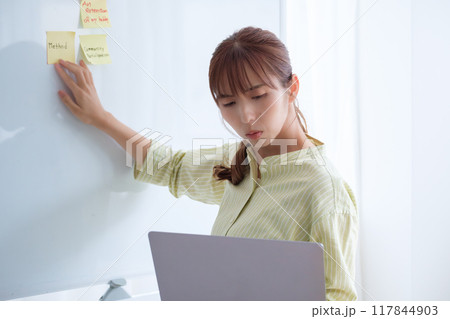 オフィスで課題を見える化する若い女性 117844903