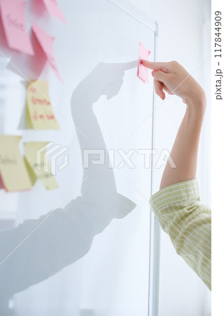 オフィスで課題を見える化する若い女性 117844909