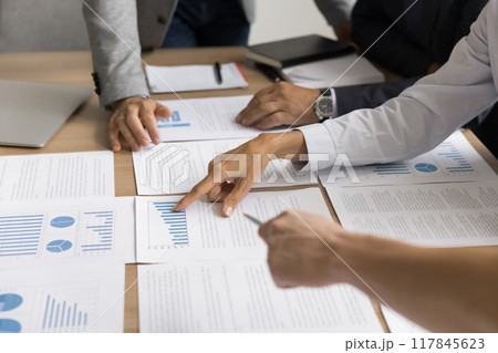 Professionals gathered around table to examining and discussing documents, closeup 117845623