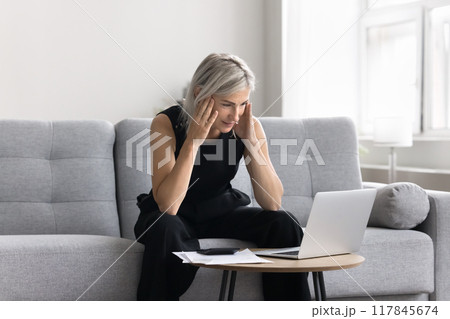 Woman looking at laptop screen read e-mail, review new rates 117845674