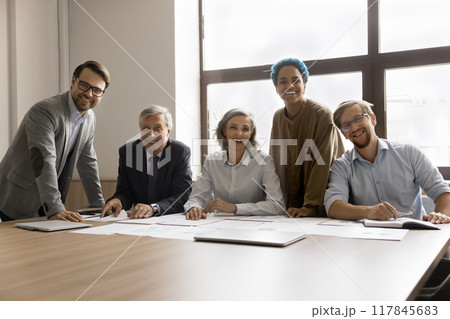 Five multiracial teammates gathered in conference room Five multiracial teammates gathered in conference room 117845683