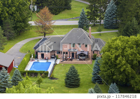 Two-story residential house with swimming pool in rural living area in Rochester, NY. American dream home as example of real estate development in US suburbs Two-story residential house with swimming pool in rural living area in Rochester, NY. American dream home as example of real estate development in US suburbs 117846218