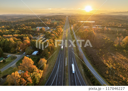 USA highway transportation infrastructure at sunset. American freeway road with fast driving cars USA highway transportation infrastructure at sunset. American freeway road with fast driving cars 117846227