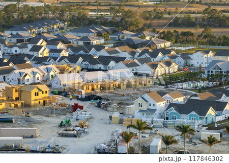 Wooden houses under construction in new developing suburban area. Development of residential housing in American suburbs. Real estate market in the USA Wooden houses under construction in new developing suburban area. Development of residential housing in American suburbs. Real estate market in the USA 117846302