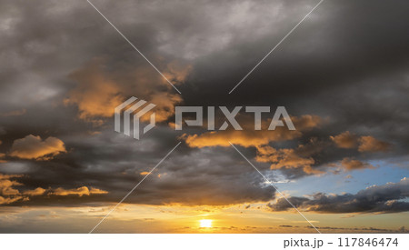 Sunset sky with bright colorful orange and yellow clouds. Panoramic skyscape 117846474