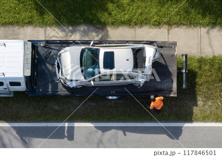 Traffic accident with tow truck hauling smashed vehicle on car crash site. First responders helping on road emergency in Florida, USA 117846501