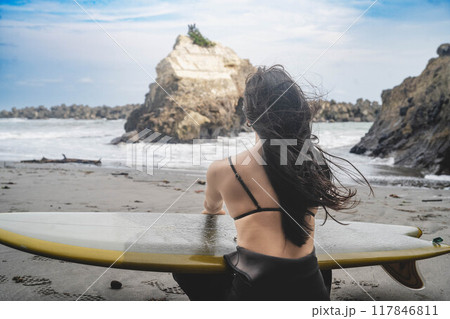 海でサーフィンをする女性の後ろ姿 117846811