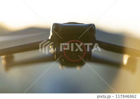 Drone quadcopter with digital camera and fast rotating propellers flying taking video and pictures 117846862