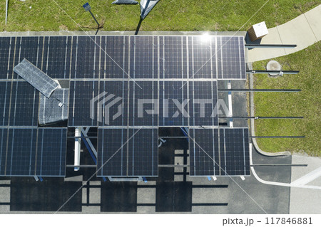 Failing of photovoltaic technology integrated in urban infrastructure. Hurricane wind damage to solar panels installed as shade roof over parking lot for parked electric cars Failing of photovoltaic technology integrated in urban infrastructure. Hurricane wind damage to solar panels installed as shade roof over parking lot for parked electric cars 117846881
