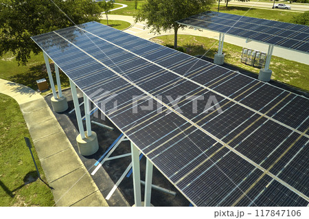 Aerial view of solar panels installed as shade roof over parking lot for parked cars for effective generation of clean electricity. Photovoltaic technology integrated in urban infrastructure 117847106