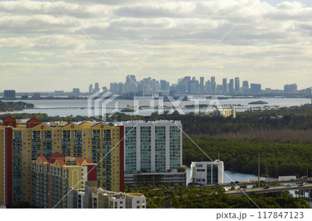 Aerial view of Sunny Isles Beach city with luxurious highrise hotels and condos on Atlantic ocean shore. American tourism infrastructure in southern Florida Aerial view of Sunny Isles Beach city with luxurious highrise hotels and condos on Atlantic ocean shore. American tourism infrastructure in southern Florida 117847123