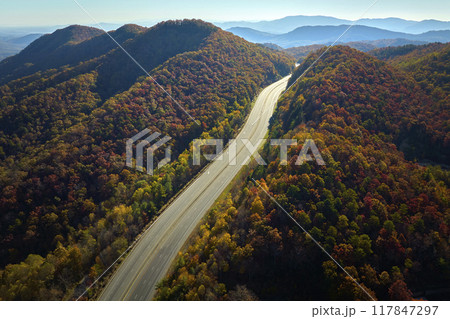 Aerial view of empty I-40 freeway in North Carolina leading to Asheville through Appalachian mountains in golden fall season. Energy crisis and high gas prices concept 117847297