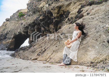 海の岸壁に寄りかかる若い女性 海の岸壁に寄りかかる若い女性 117847971