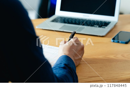 相続税申告書の記入をする男性の手元 相続税申告書の記入をする男性の手元 117848445