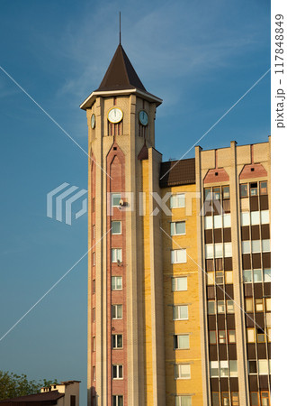 A tall, cone-shaped tower building in the city. Street clock on the tower 117848849