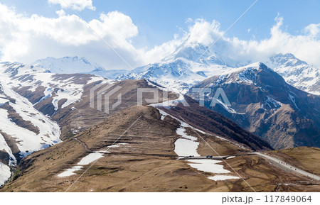 Georgian mountain landscape with a road and Mount Kazbek Georgian mountain landscape with a road and Mount Kazbek 117849064