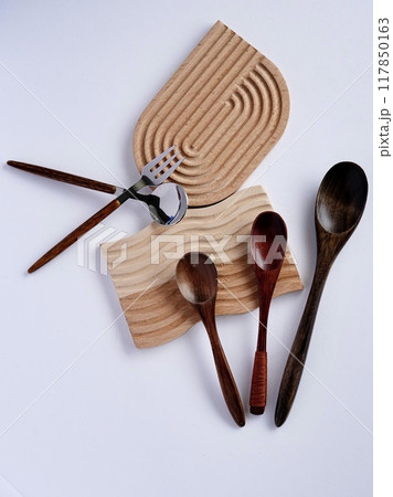 普段使いのカトラリーを木製コースターに乗せて白背景で 117850163