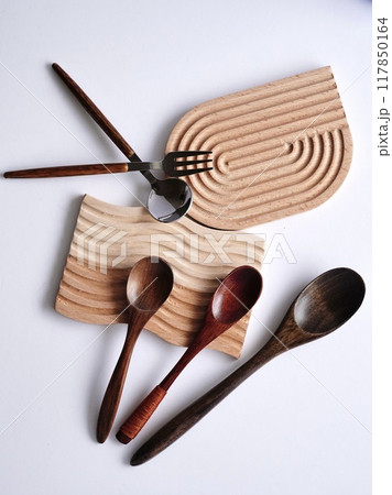 普段使いのカトラリーを木製コースターに乗せて白背景で 117850164