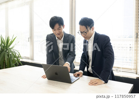 社内で打ち合わせをする2人の男性社員 社内で打ち合わせをする2人の男性社員 117850957