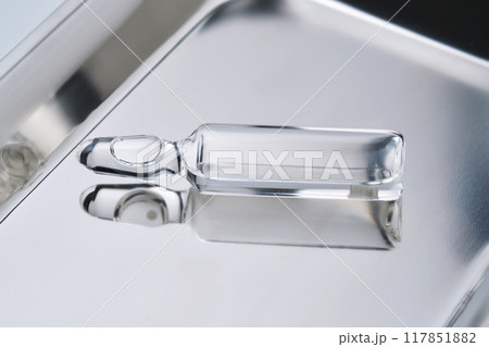 Glass ampoules in a steel medical tray. Glass ampoules in a steel medical tray. 117851882