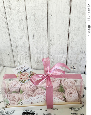 A box of homemade marshmallows. Tied with a ribbon. The tag has the inscription in Russian Unforgettable emotions. Flowers made of marshmallow. 117853612