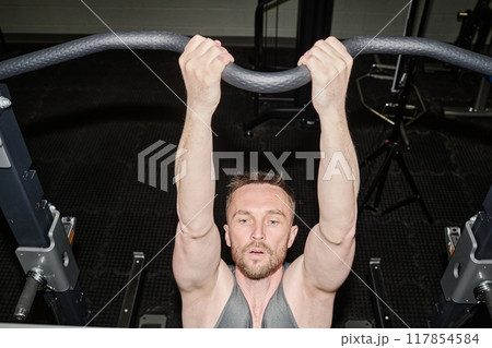 High angle shot of tired man doing pull-ups to develop muscles 117854584
