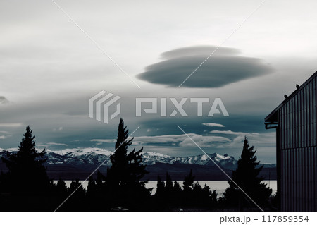 Flying saucer shaped cloud over evening lake Flying saucer shaped cloud over evening lake 117859354