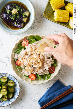 豚バラ肉の冷しゃぶサラダに胡麻だれをかける 117860097