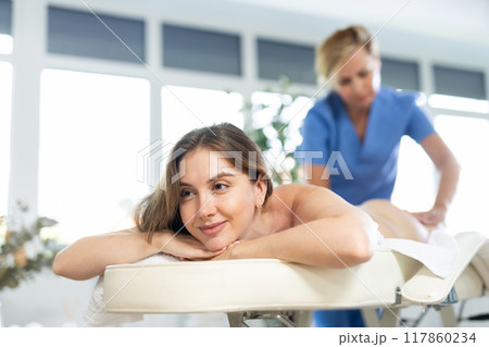 Massage therapist makes massage 117860234