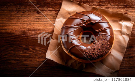 木のテーブルの上に美味しそうなチョコレートドーナツがのっています 木のテーブルの上に美味しそうなチョコレートドーナツがのっています 117861884