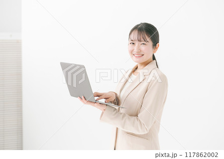 パソコンを持つ20代女性 117862002