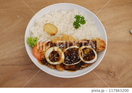 Rice with fried chicken and onion in white plate on wooden table 117863200