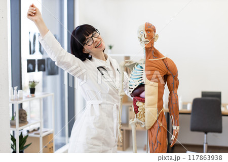 Smiling female doctor with anatomy model in medical office 117863938