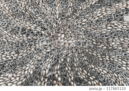 Mosaic ground pavement with radial pattern of black and white pebble stones 117865120