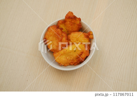 Corn croquettes in a bowl on a wooden table 117867011