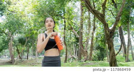 Asian woman refreshing with water after active park session 117868459