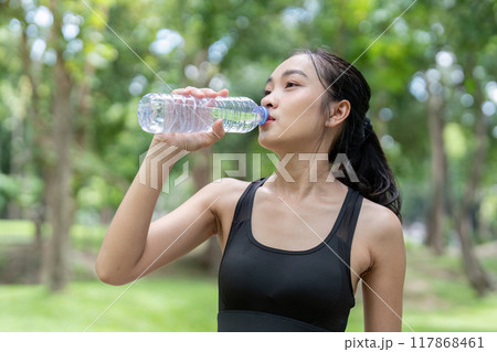 Asian woman staying hydrated with water bottle during park exercise 117868461