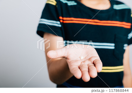 Kid holds fallen baby tooth highlighting dental hygiene. First tooth loss symbolizing development and growth in adolescence. Children show teeth new gap, dentist problems Kid holds fallen baby tooth highlighting dental hygiene. First tooth loss symbolizing development and growth in adolescence. Children show teeth new gap, dentist problems 117868844