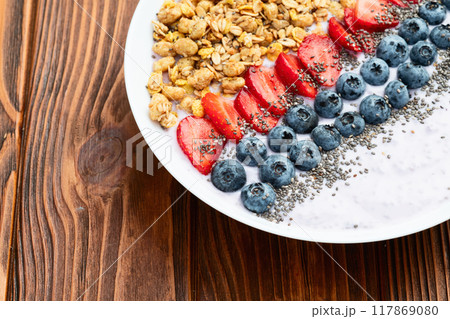 Healthy breakfast . Yogurt with berries ( strawberry , raspberry , blueberry , blackberry ) , granola and chia seeds . Top view 117869080