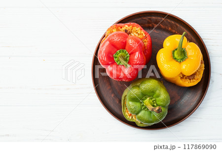 Baked stuffed pepper ( paprika ) with rice , carrot and meat . Top view on rustic background Baked stuffed pepper ( paprika ) with rice , carrot and meat . Top view on rustic background 117869090