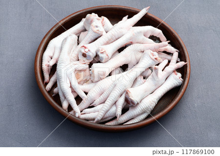 Raw chicken foot ( paws ) Top view on rustic background 117869100