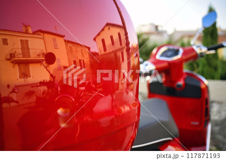 Intense red motorcycle with house and buildings reflections in Antibes, France Intense red motorcycle with house and buildings reflections in Antibes, France 117871193