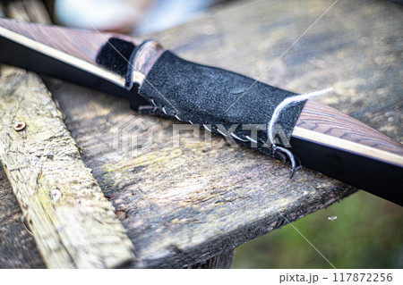 Timeless Elegance of a Traditional Bow Resting on Aged Wood Timeless Elegance of a Traditional Bow Resting on Aged Wood 117872256