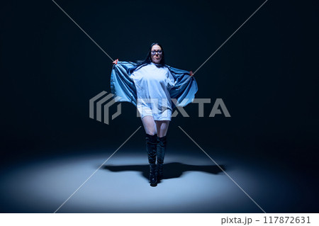 Creative blend of hip-hop and high heels dance styles. Talented and artistic young woman performing against black studio background 117872631